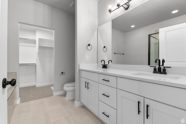 1470 N Shadow Wood Dr, Kaysville, UT 84037 - full bath featuring double vanity, a shower stall, toilet, a walk in closet, and baseboards