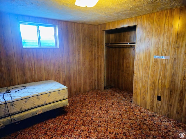 719 Adams St, Montpelier, ID 83254 - bedroom featuring wood walls, carpet flooring, a closet, and a textured ceiling