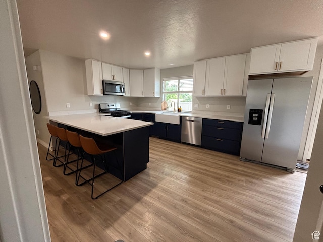 1574 S 2000 E, Vernal, UT 84078 - kitchen featuring appliances with stainless steel finishes, a sink, light wood finished floors, white cabinets, and recessed lighting