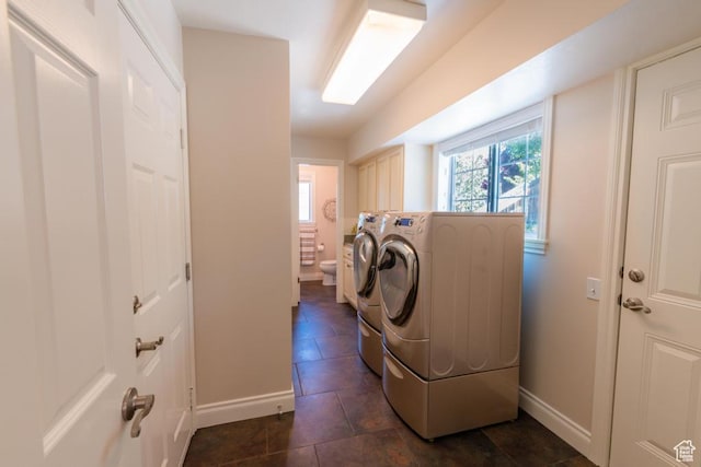 1814 N Heather Dr, Orem, UT 84097 - laundry area with washer and clothes dryer, cabinet space, baseboards, and dark tile patterned floors