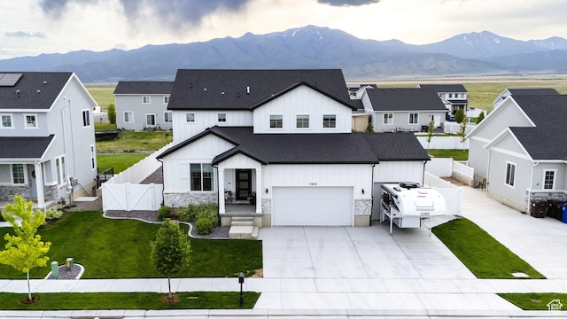 7939 N Seattle Slew Rd E, Eagle Mountain, UT 84005 - modern farmhouse style home with board and batten siding, a gate, a mountain view, and driveway