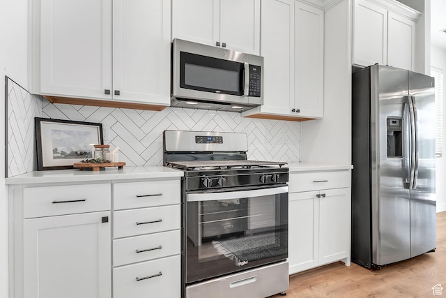 1797 N Avocet Dr, Salem, UT 84653 - kitchen featuring stainless steel appliances, light countertops, white cabinets, light wood finished floors, and tasteful backsplash