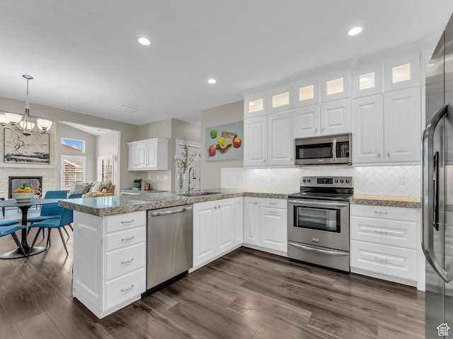 10486 S Harvest Glory Dr W Unit 125, South Jordan, UT 84095 - kitchen with stainless steel appliances, a sink, a peninsula, decorative backsplash, and glass insert cabinets