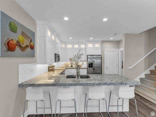 10486 S Harvest Glory Dr W Unit 125, South Jordan, UT 84095 - kitchen featuring stainless steel appliances, a sink, a peninsula, dark wood-type flooring, and white cabinets