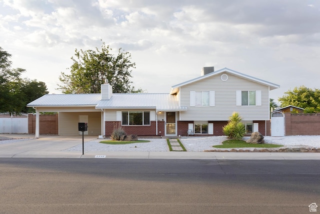 2395 E 700 N, St George, UT 84790 - split level home with a chimney, concrete driveway, a carport, metal roof, and brick siding