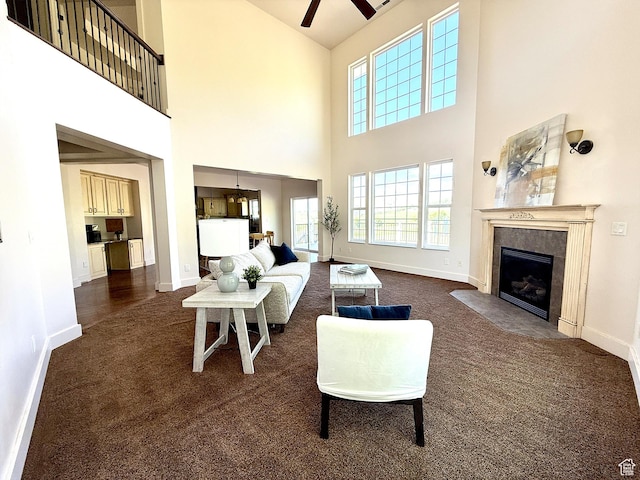 2307 Maple Leaf Dr, Cove, UT 84320 - living room featuring dark colored carpet, ceiling fan, a fireplace with flush hearth, and a towering ceiling