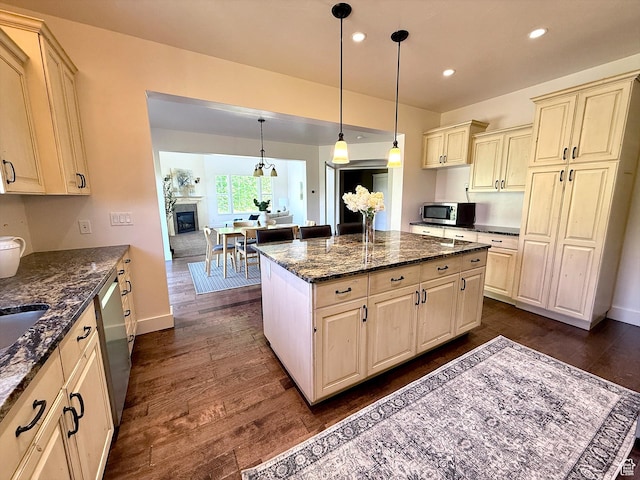 2307 Maple Leaf Dr, Cove, UT 84320 - kitchen with appliances with stainless steel finishes, cream cabinets, dark wood-type flooring, recessed lighting, and dark stone countertops
