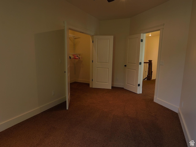 2307 Maple Leaf Dr, Cove, UT 84320 - unfurnished bedroom featuring dark colored carpet, a walk in closet, and baseboards