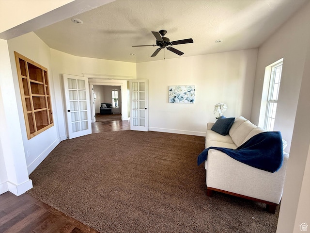 2307 Maple Leaf Dr, Cove, UT 84320 - living area with french doors, a ceiling fan, built in features, dark carpet, and dark wood-style flooring