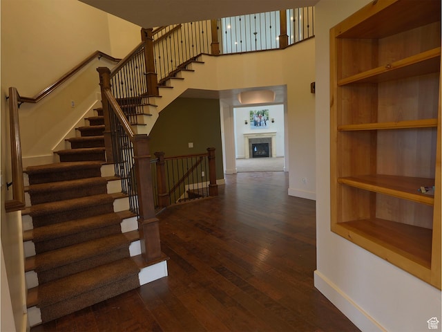 2307 Maple Leaf Dr, Cove, UT 84320 - staircase with baseboards, a towering ceiling, hardwood / wood-style flooring, and a fireplace