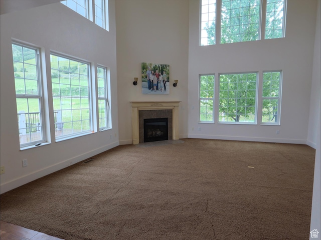 2307 Maple Leaf Dr, Cove, UT 84320 - unfurnished living room with a high ceiling, baseboards, plenty of natural light, a tile fireplace, and carpet