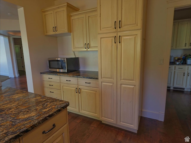 2307 Maple Leaf Dr, Cove, UT 84320 - kitchen with stainless steel microwave, dark wood-style flooring, dark stone countertops, and baseboards