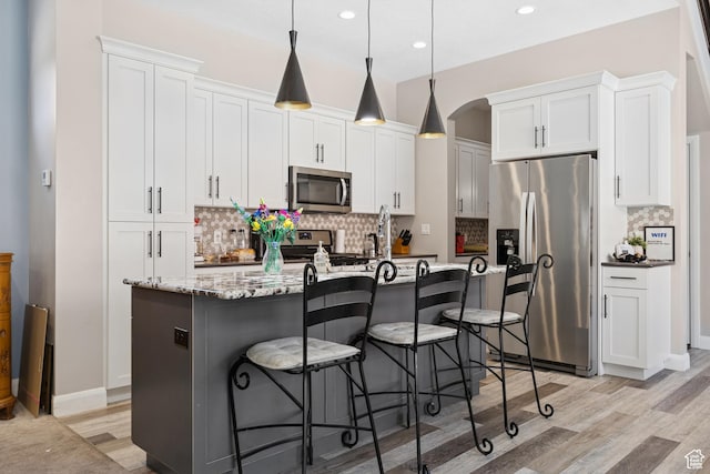 536 N Creek Cir, Washington, UT 84780 - kitchen featuring appliances with stainless steel finishes, light wood finished floors, backsplash, white cabinetry, and recessed lighting