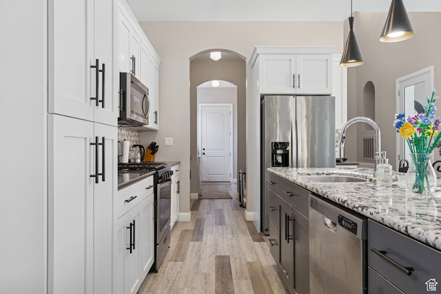 536 N Creek Cir, Washington, UT 84780 - kitchen featuring appliances with stainless steel finishes, light wood finished floors, white cabinetry, and light stone countertops