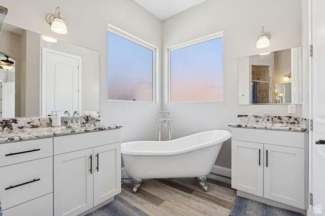 536 N Creek Cir, Washington, UT 84780 - bathroom with wood finished floors, two vanities, a soaking tub, and a stall shower