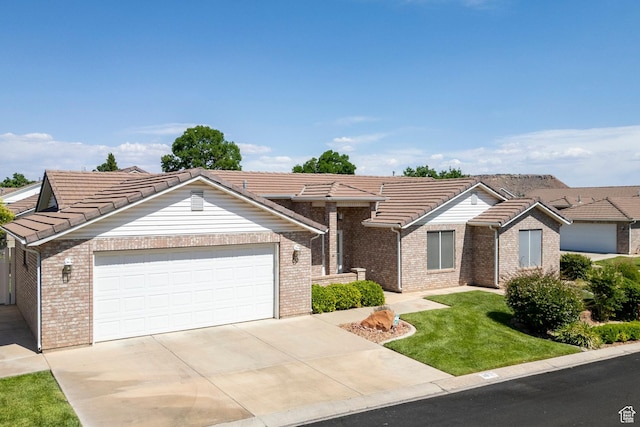 1040 S 1100 E Unit 80, St George, UT 84790 - view of front of house featuring a tile roof, brick siding, a front yard, and a garage