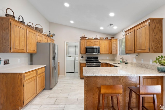 1040 S 1100 E Unit 80, St George, UT 84790 - kitchen with stainless steel appliances, washing machine and clothes dryer, a peninsula, a sink, and vaulted ceiling
