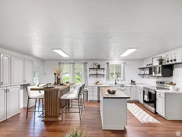 5432 S 800 E, South Ogden, UT 84405 - kitchen with appliances with stainless steel finishes, a kitchen island, open shelves, healthy amount of natural light, and a textured ceiling