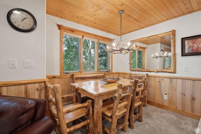 3988 N Timber Wolf Ln Unit 10D, Park City, UT 84098 - dining area with a chandelier, wood walls, a wainscoted wall, wood ceiling, and light carpet