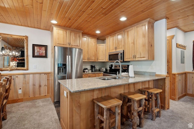 3988 N Timber Wolf Ln Unit 10D, Park City, UT 84098 - kitchen with stainless steel appliances, a wainscoted wall, wood ceiling, carpet, and a peninsula