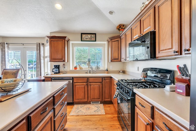 6329 W Basin Ridge Dr, West Valley City, UT 84128 - kitchen featuring black appliances, a sink, brown cabinetry, light wood-style flooring, and light countertops