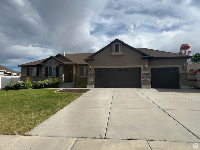 6329 W Basin Ridge Dr, West Valley City, UT 84128 - view of front of property featuring an attached garage, a front lawn, stone siding, and driveway