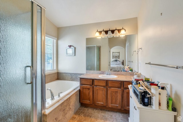 6329 W Basin Ridge Dr, West Valley City, UT 84128 - ensuite bathroom featuring a shower stall, vanity, a garden tub, and tile patterned floors
