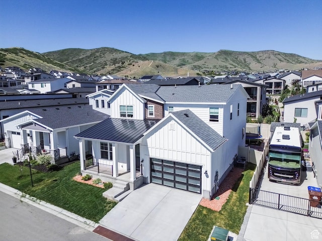 14908 S Fawley Ln, Herriman, UT 84096 - view of front facade featuring board and batten siding, a residential view, a standing seam roof, driveway, and a garage