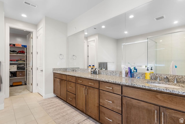 14908 S Fawley Ln, Herriman, UT 84096 - bathroom with double vanity, a stall shower, a walk in closet, tile patterned flooring, and recessed lighting