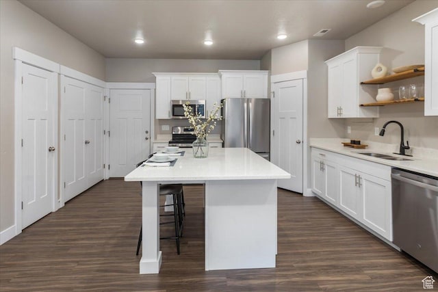 1704 E Talon Way, Eagle Mountain, UT 84005 - kitchen featuring appliances with stainless steel finishes, a sink, white cabinets, a kitchen bar, and recessed lighting