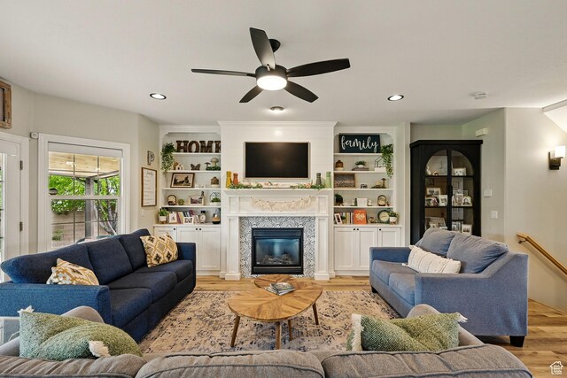 2271 W Crestview Cir, Cedar City, UT 84720 - living room featuring light wood finished floors, a ceiling fan, a tiled fireplace, recessed lighting, and built in shelves