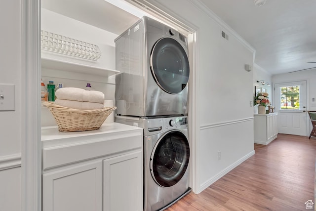1030 S Orem Blvd Unit 23, Orem, UT 84058 - laundry area with estacked washer and dryer, light wood-type flooring, crown molding, baseboards, and cabinet space