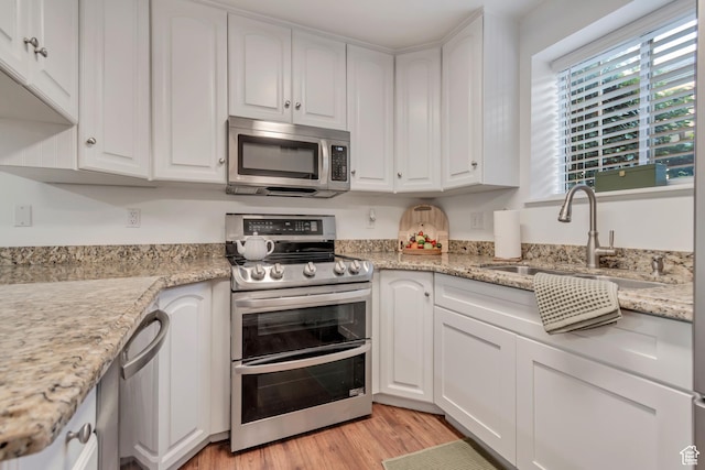 1030 S Orem Blvd Unit 23, Orem, UT 84058 - kitchen with stainless steel appliances, a sink, white cabinetry, and light wood finished floors