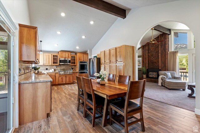 4456 N 3800 W, Peterson, UT 84050 - dining room with arched walkways, beam ceiling, high vaulted ceiling, ceiling fan, and a fireplace
