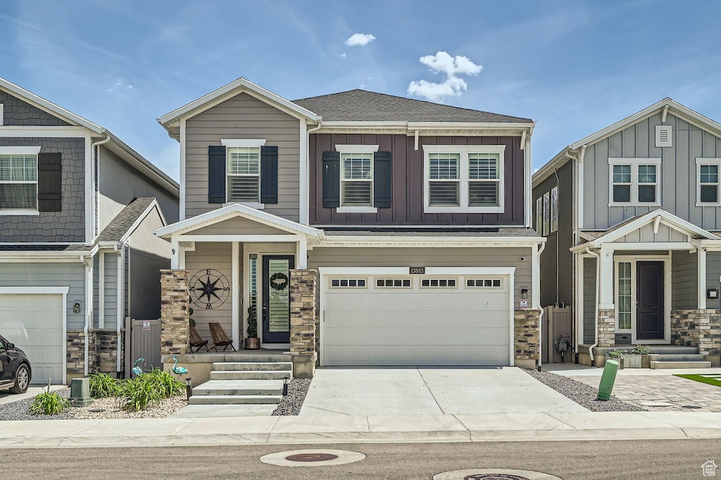 13883 S Rockwell Ln, Draper Ut Cnty, UT 84020 - craftsman-style house with stone siding, a garage, concrete driveway, and board and batten siding