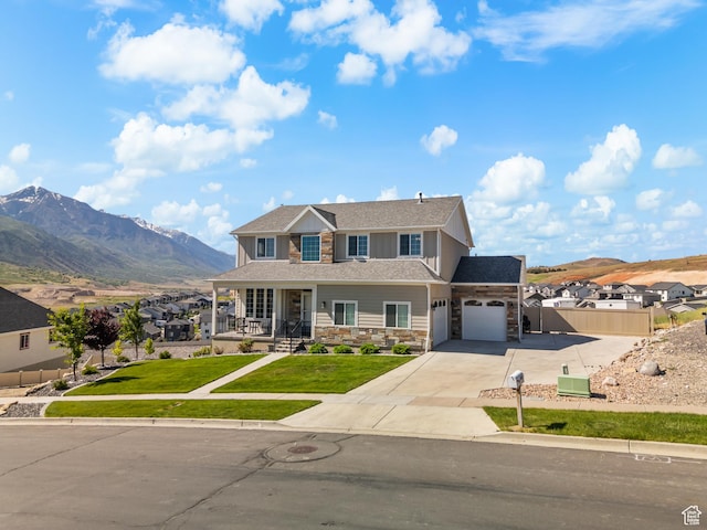 1353 Sageberry Dr, Santaquin, UT 84655 - view of front facade with stone siding, an attached garage, concrete driveway, covered porch, and a mountain view