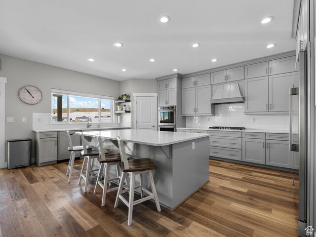 1353 Sageberry Dr, Santaquin, UT 84655 - kitchen featuring gray cabinetry, premium range hood, stainless steel appliances, decorative backsplash, and a kitchen island