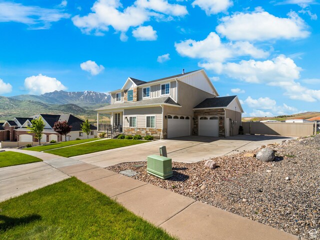 1353 Sageberry Dr, Santaquin, UT 84655 - view of front facade with stone siding, driveway, a mountain view, and a garage