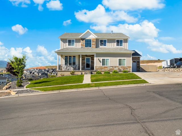 1353 Sageberry Dr, Santaquin, UT 84655 - view of front of house with stone siding, covered porch, concrete driveway, board and batten siding, and a front yard