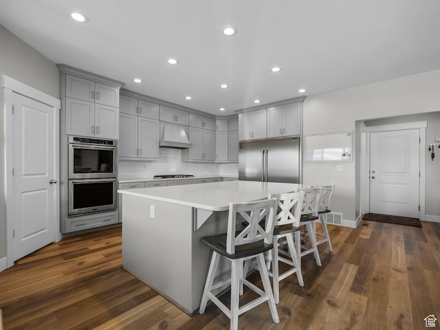 1353 Sageberry Dr, Santaquin, UT 84655 - kitchen featuring gray cabinets, appliances with stainless steel finishes, custom exhaust hood, light countertops, and a kitchen island