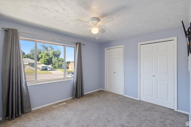 399 E 400 N Unit 2A, Bountiful, UT 84010 - unfurnished bedroom with two closets, carpet flooring, ceiling fan, and a textured ceiling