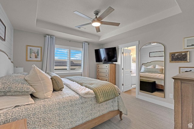 12473 S Desert Mesa Dr, Herriman, UT 84096 - bedroom featuring a raised ceiling, light carpet, ceiling fan, connected bathroom, and baseboards