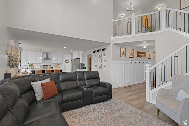 12473 S Desert Mesa Dr, Herriman, UT 84096 - living room featuring wood finished floors, stairway, a towering ceiling, and recessed lighting