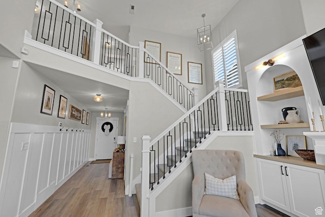12473 S Desert Mesa Dr, Herriman, UT 84096 - stairway featuring wood finished floors, a towering ceiling, and baseboards