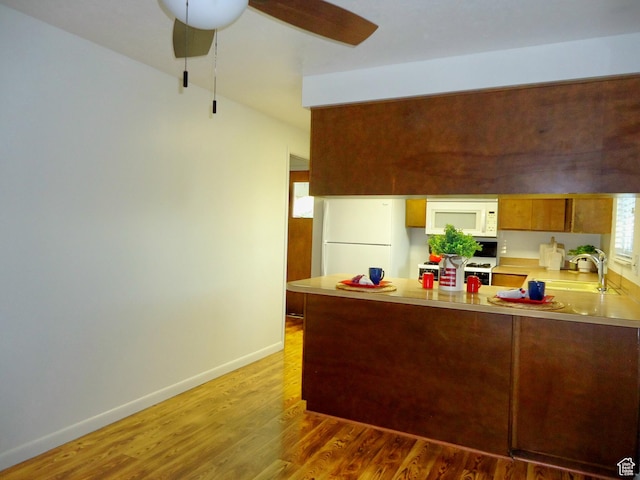 783 N Highland Blvd, Brigham City, UT 84302 - kitchen featuring white appliances, a peninsula, light countertops, ceiling fan, and light wood-type flooring