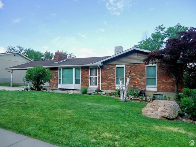 783 N Highland Blvd, Brigham City, UT 84302 - ranch-style home featuring a chimney, a front yard, and brick siding