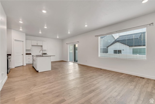 3800 W 560 N Unit 509, Lehi, UT 84043 - kitchen featuring dark countertops, a sink, recessed lighting, baseboards, and light wood-type flooring