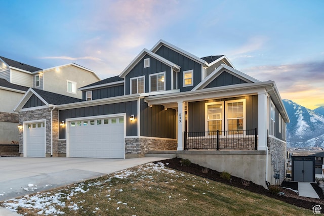 833 N Union Bench Dr W Unit 62, Mapleton, UT 84664 - view of front of home with board and batten siding, a porch, driveway, a garage, and stone siding