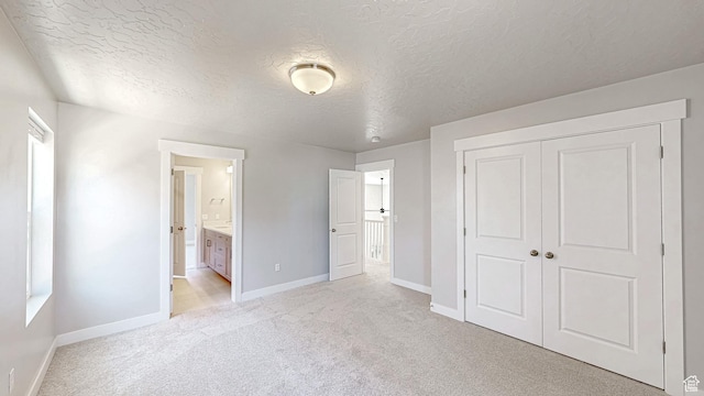 833 N Union Bench Dr W Unit 62, Mapleton, UT 84664 - unfurnished bedroom with baseboards, light carpet, a textured ceiling, a closet, and connected bathroom