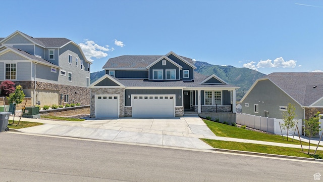 833 N Union Bench Dr W Unit 62, Mapleton, UT 84664 - view of front of house featuring driveway, stone siding, a mountain view, a garage, and board and batten siding